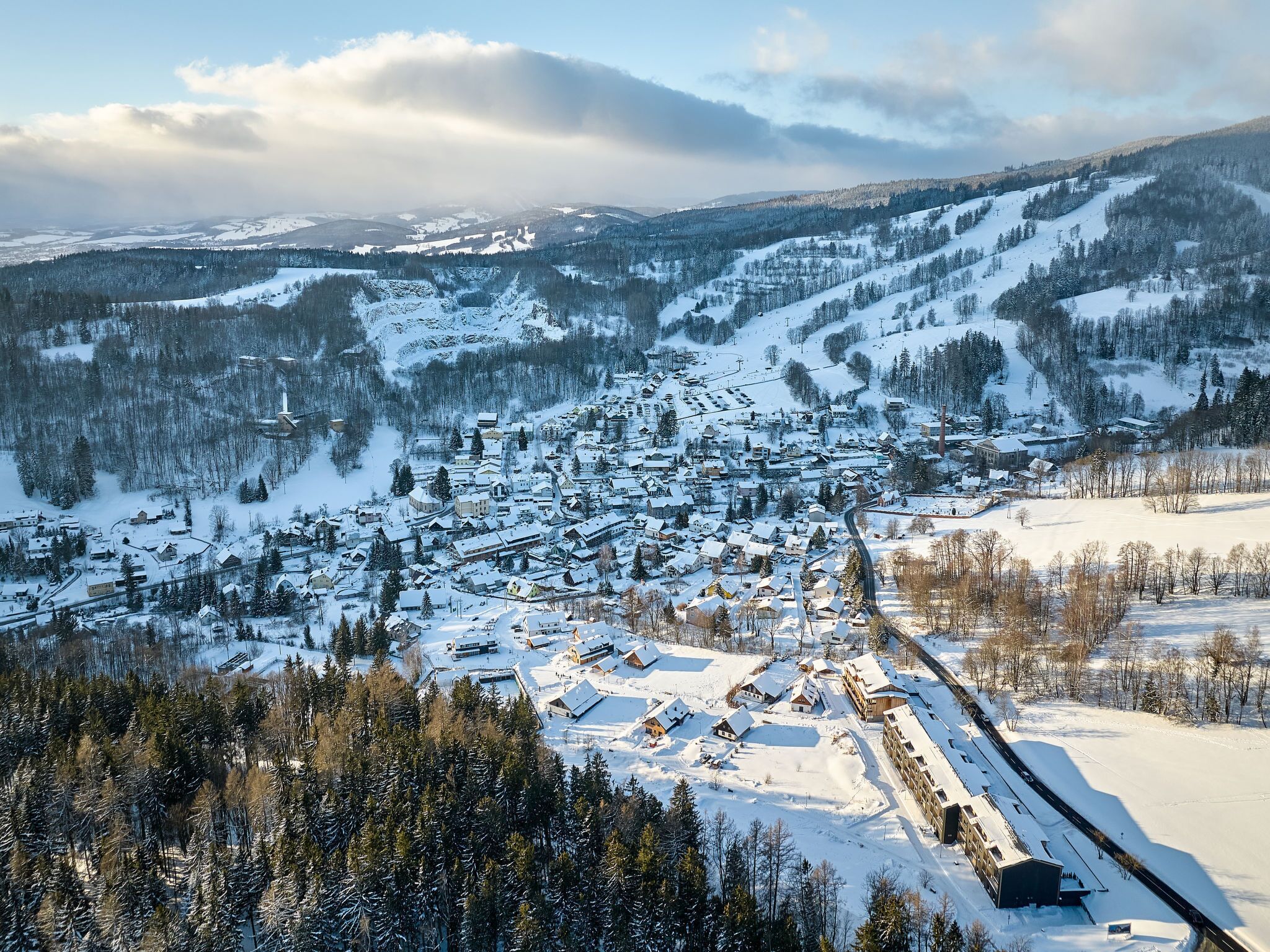 Un village enneigé, avec des bâtiments et une piste de ski.