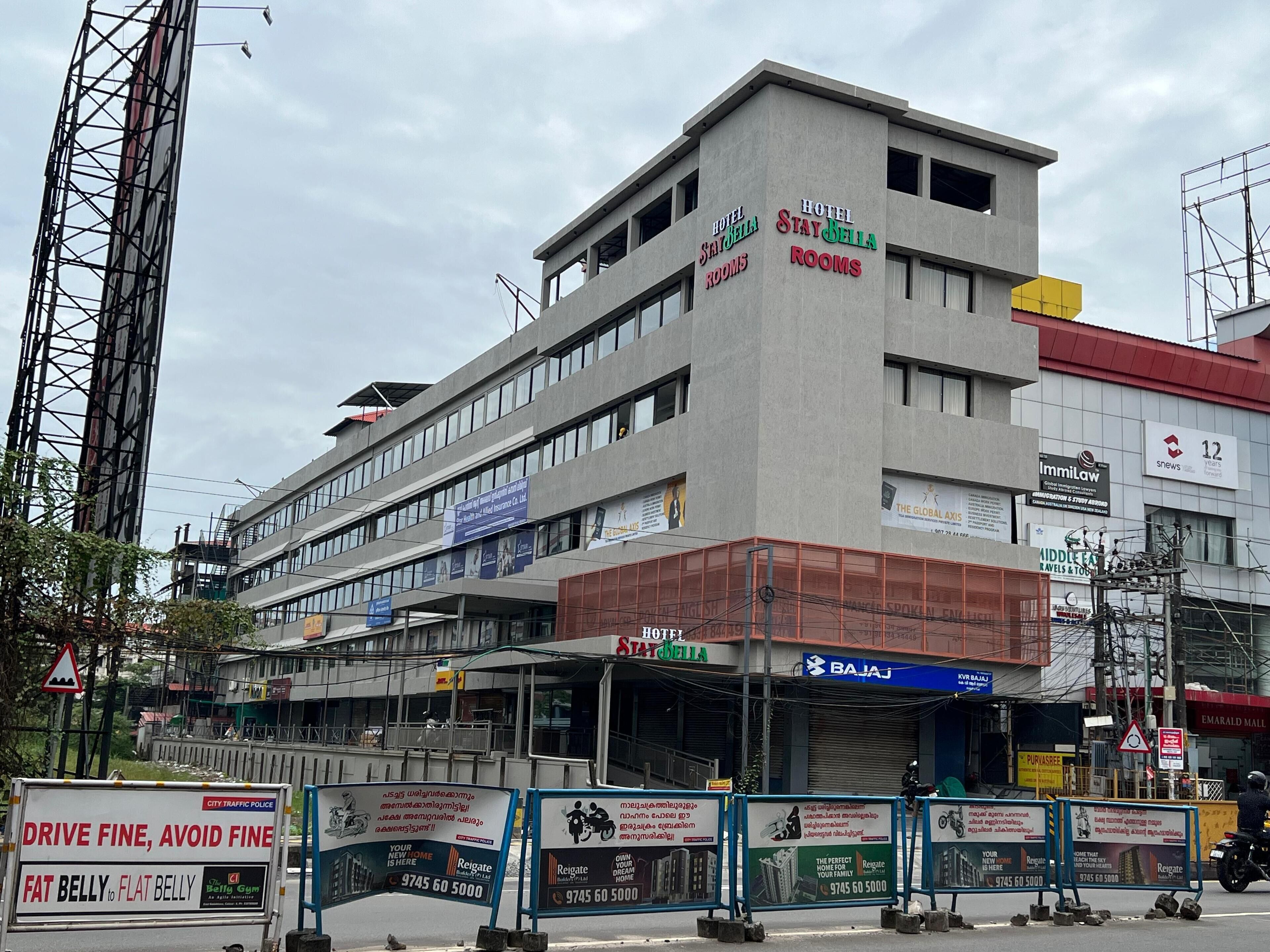 A multi-story hotel with signage for 'Hotel Stay Bella Rooms'.