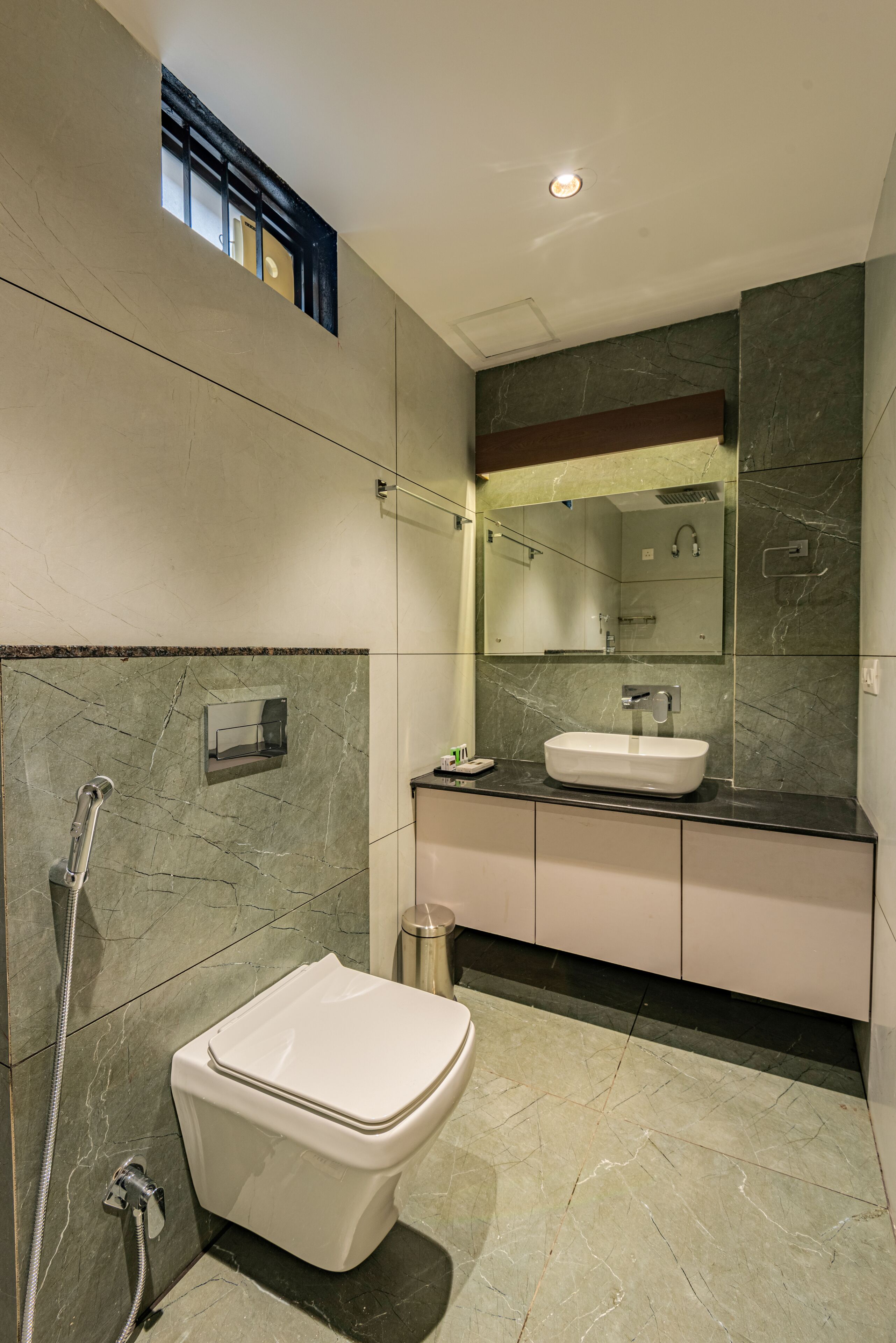 A modern bathroom with a white toilet, a sink, and a shower.