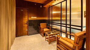 Una habitación con techo de madera, separador de vidrio, banca de madera y una silla.