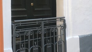 A black door with a brass doorknob and a small number '7' sign on the wall beside it. - Sea Breeze Apartment (Floriana)