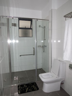 Ein modernes Badezimmer mit Duschkabine, Toilette und Waschbecken.