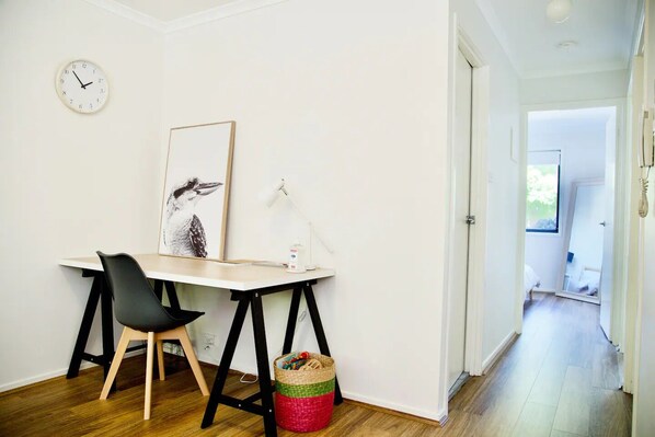 Una habitación con un escritorio, una silla y un cuadro en la pared.