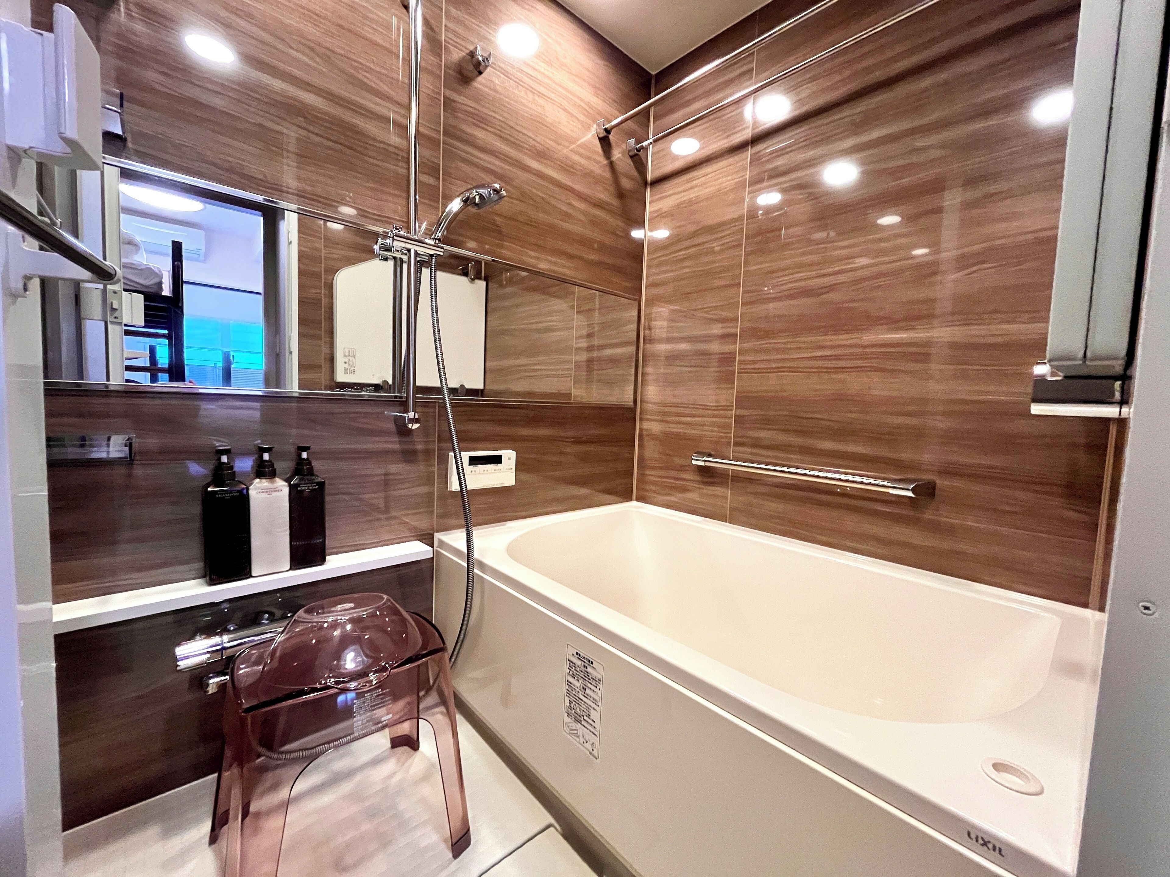 Ein modernes Badezimmer mit einer großen Badewanne, einer Duschkabine aus Glas und einem Waschtisch mit Pflegeartikeln.