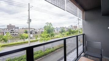 Un balcón con vista a un paisaje urbano, que incluye edificios y un río.