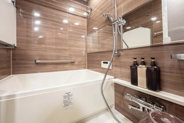 Un baño moderno con una bañera blanca, cabina de ducha con paredes de cristal y un espejo sobre el lavabo.