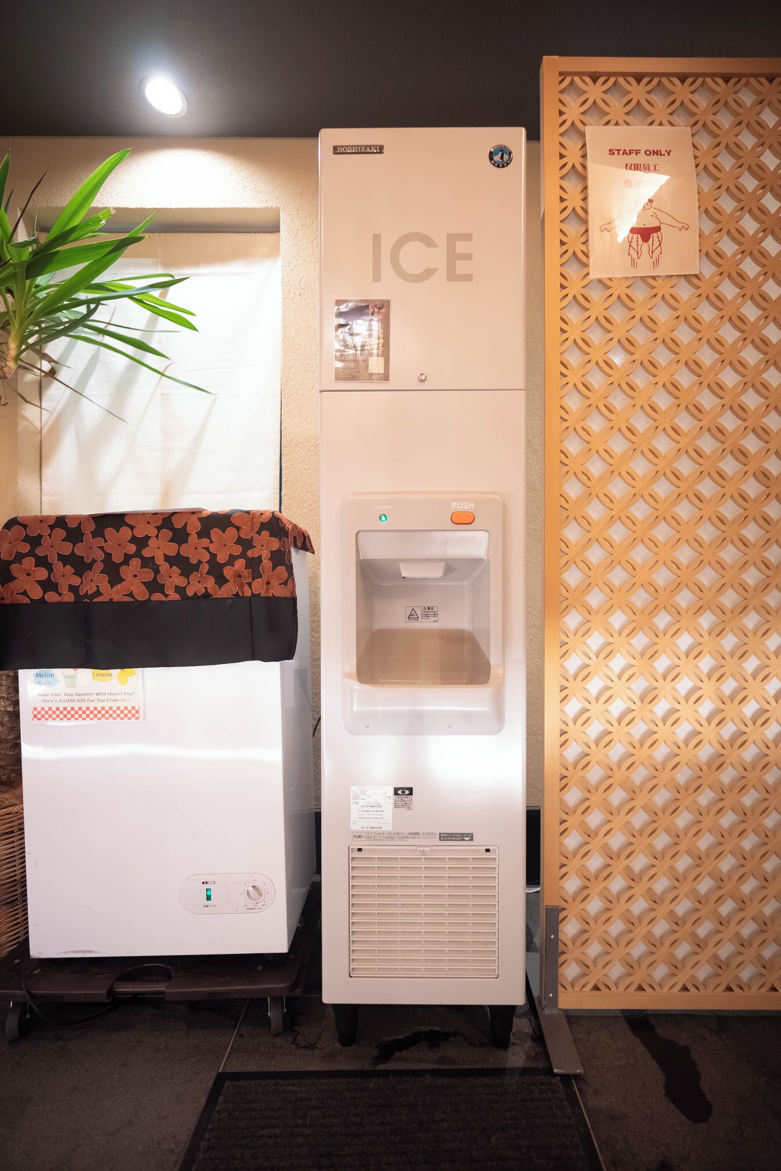 A refrigerator with an ice dispenser, a freezer, and a vending machine.