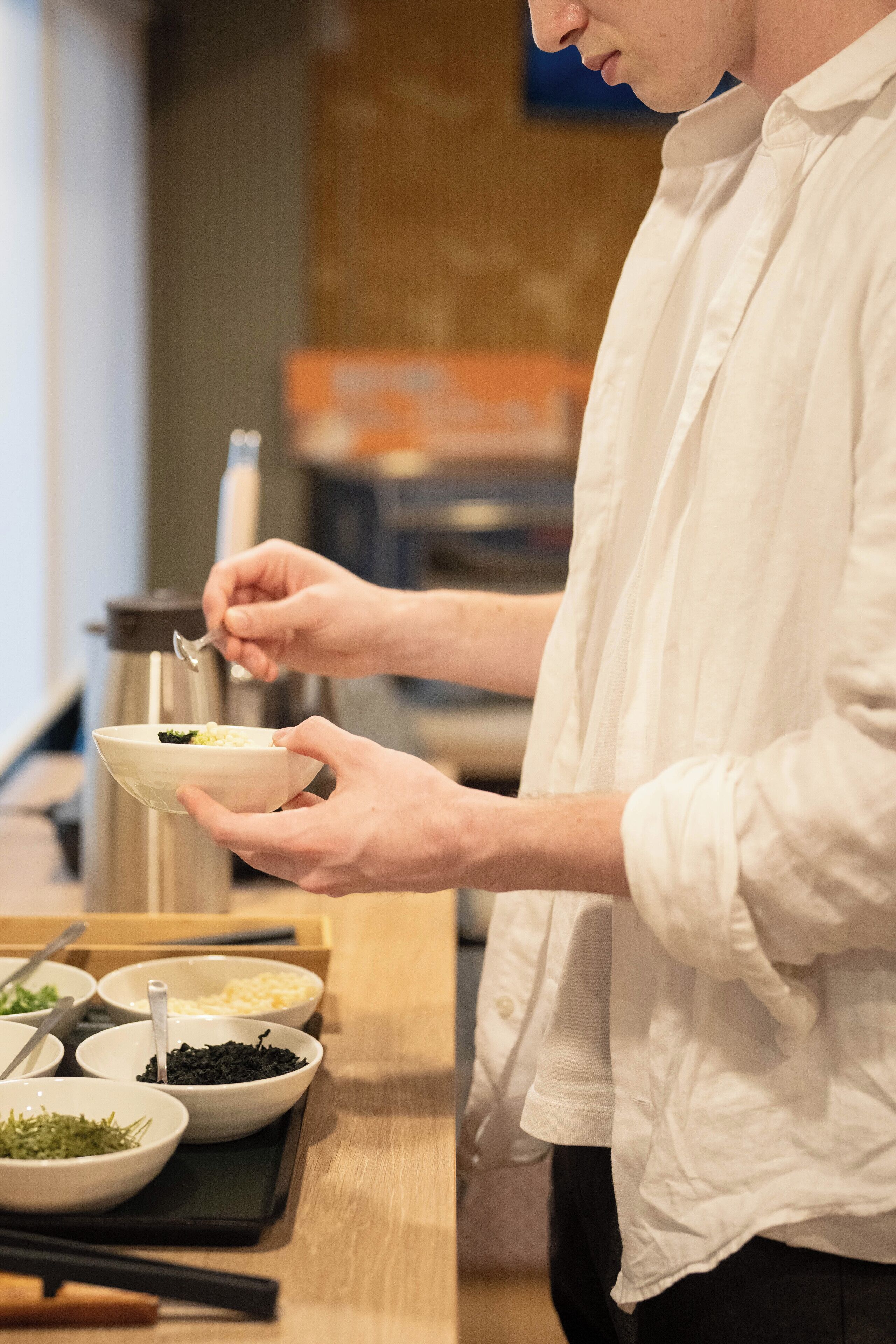 A person preparing food with various ingredients and utensils on a counter.