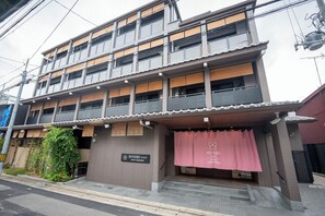 Un edificio de varios pisos con un letrero que dice Hiyori Stay.