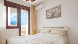 Een slaapkamer met een bed, een raam en een wandairconditioner.