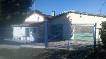 A fenced property with a building that has a red roof and a white exterior.