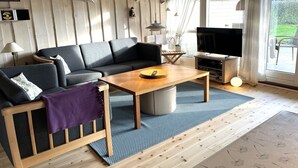 Un salon confortable avec un canapé, une table basse et un téléviseur.