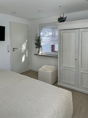 Un dormitorio con cama, ventana con vistas, planta y armario.