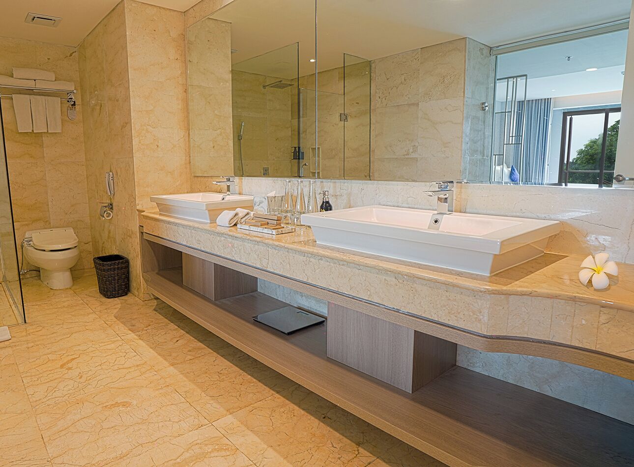 Ein modernes Badezimmer mit einem großen Spiegel, zwei Waschbecken, einer Dusche und einem WC.