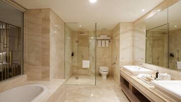 A modern bathroom with a glass-enclosed shower, a freestanding bathtub, and a vanity with two sinks and a large mirror.