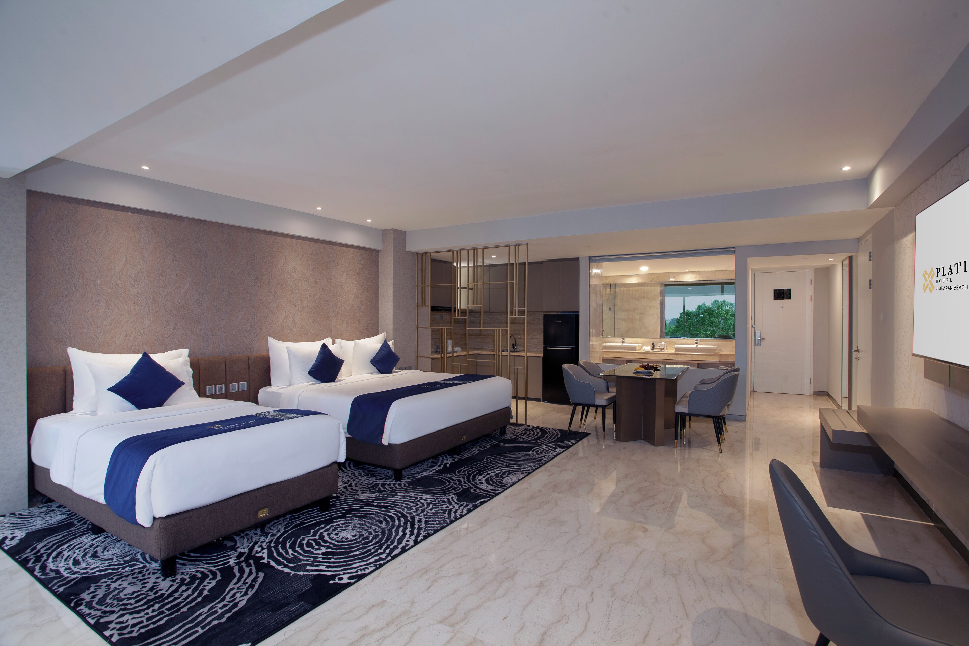 A modern hotel room with two beds, a desk, and a view of the outdoors.