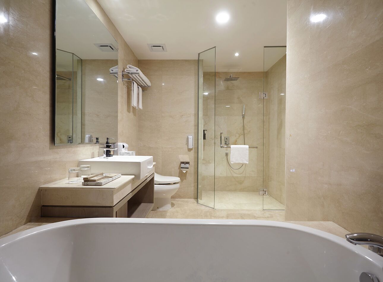Un baño moderno con una bañera independiente, una ducha con mampara de vidrio y un inodoro.