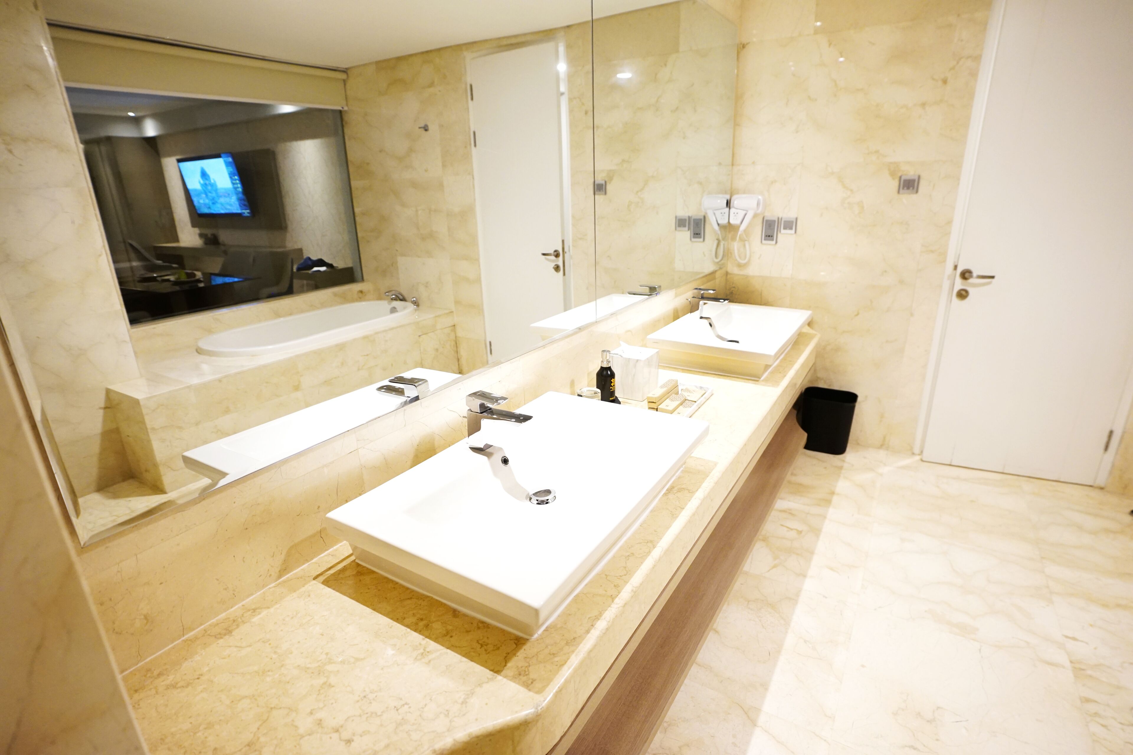 Ein modernes Badezimmer mit zwei Waschbecken, einem großen Spiegel und einem Waschtisch.