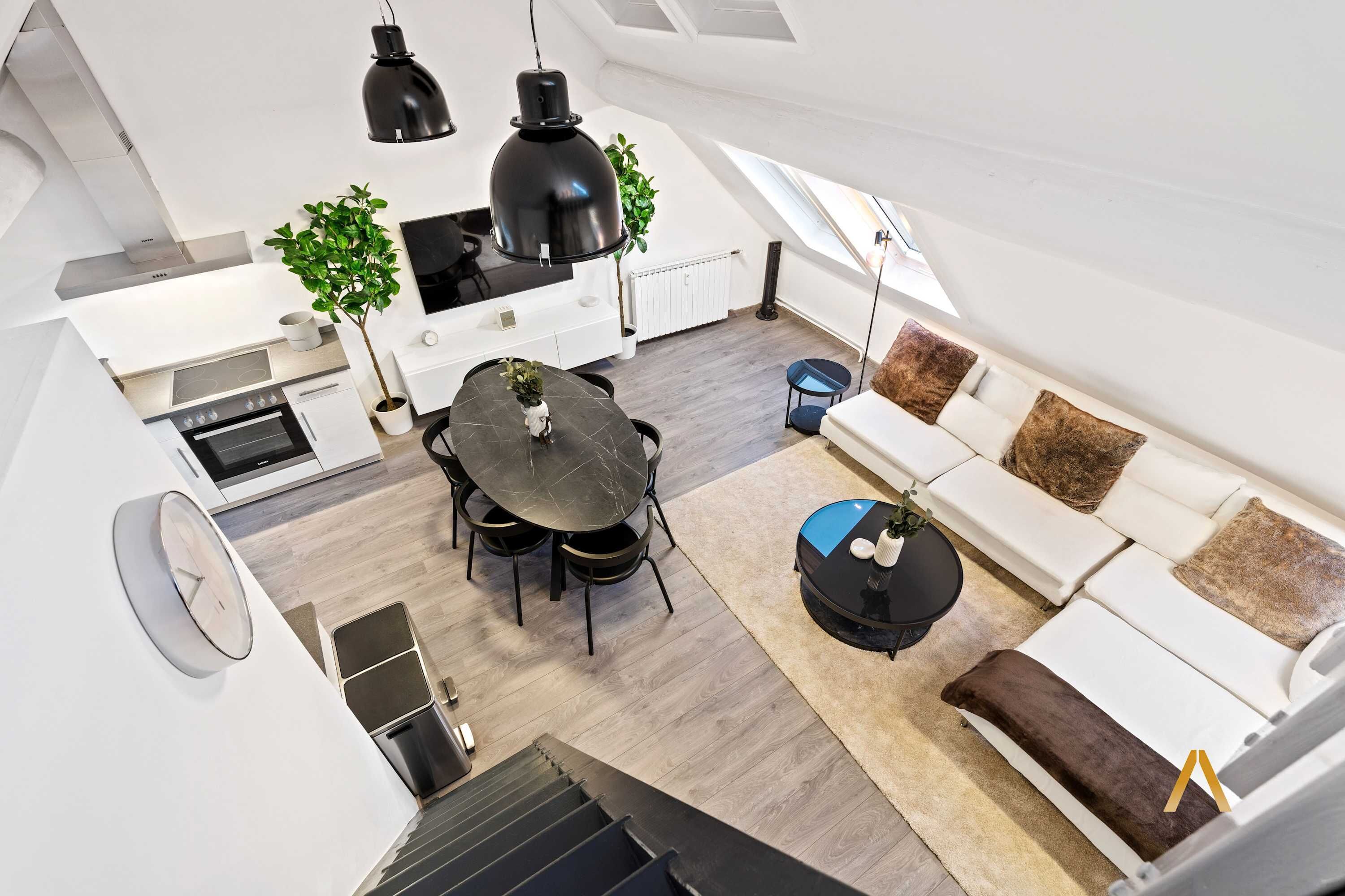 Een modern loft-appartement met een eethoek, keuken en woonruimte.