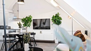 A modern loft apartment with a dining area, kitchen, and living space. - Modern Loft with Washer, TV & Near Attractions (Ville-Haute)
