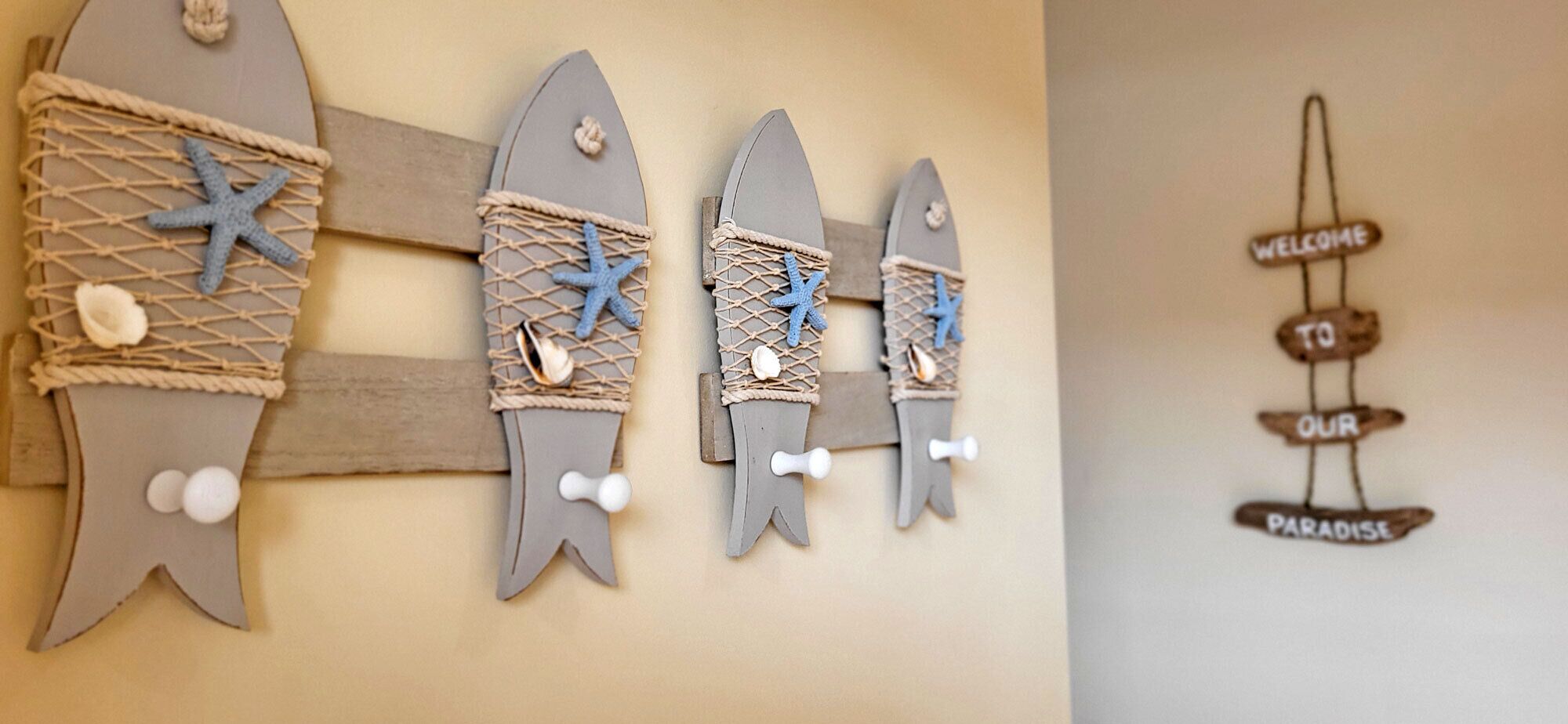 A wall with decorative fish and a welcome sign.