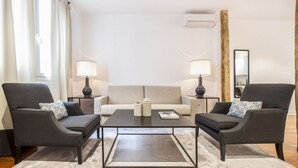 A modern living room with two armchairs, a sofa, a coffee table, and two lamps. - Superior 2 Bedroom Apartment - Chueca (Chueca)