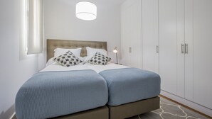 Een slaapkamer met een bed, een kledingkast en een bedlampje.