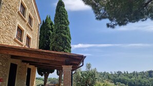 Un edificio de piedra con un patio cubierto y mobiliario de exterior.