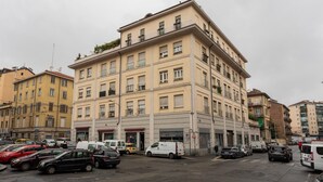 Ein mehrstöckiges Gebäude mit einer glatten Fassade, zahlreichen Fenstern und Balkonen.