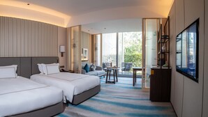 A hotel room with two beds, a sofa, a balcony with chairs, and a TV. - Nanhu Hotel (Jiaxing)