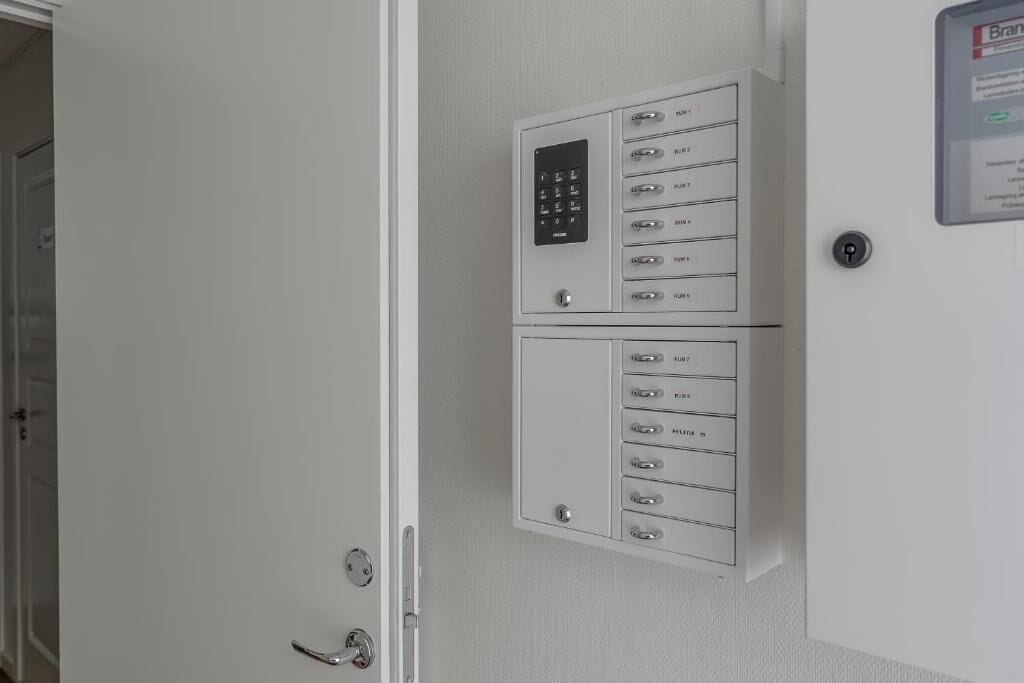Puerta blanca con cerradura electrónica y lector de tarjetas, ranura para tarjeta empotrada en la pared y picaporte.