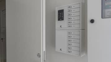 Puerta blanca con cerradura electrónica y lector de tarjetas, ranura para tarjeta empotrada en la pared y picaporte.