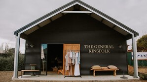A building with a sign reading 'THE GENERAL KINSFOLK' and a clothing rack outside. - Tiny Boorowa by Tiny Away (Boorowa)