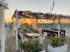 Una playa cerca, arena blanca, sillas reclinables de playa, sombrillas
