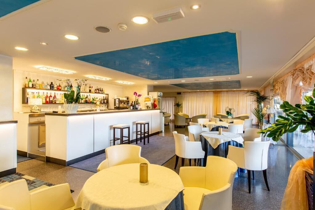 A hotel lobby with a bar area, seating arrangements, and a large window.