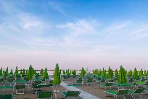 In Strandnähe, weißer Sandstrand, Liegestühle, Sonnenschirme