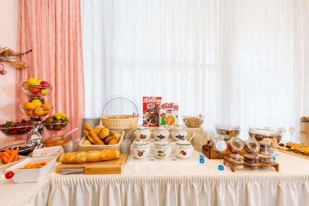A buffet table with various food items, including fruits, bread, and cereal boxes.