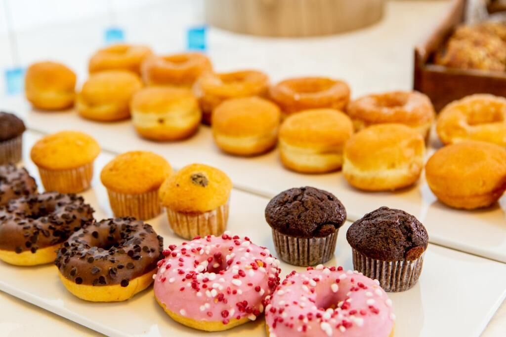 Verschiedene Backwaren, darunter Donuts, Muffins und Cupcakes.