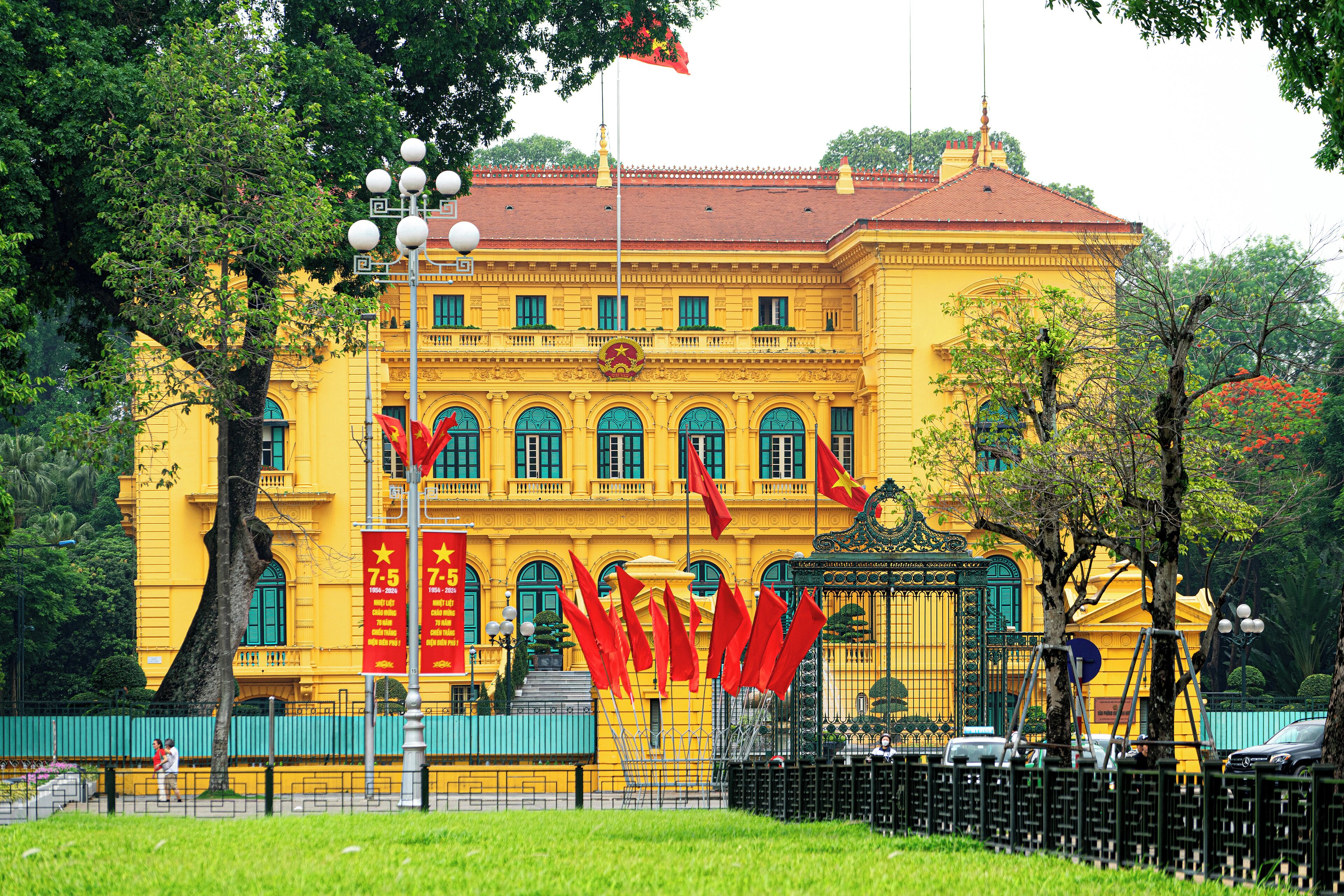 A large yellow building with multiple windows and a red roof.