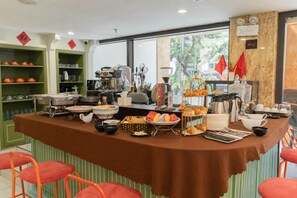 A breakfast buffet with various food items, a coffee station, and a seating area with chairs. - Wilque Hotel Hanoi (Hanoi)