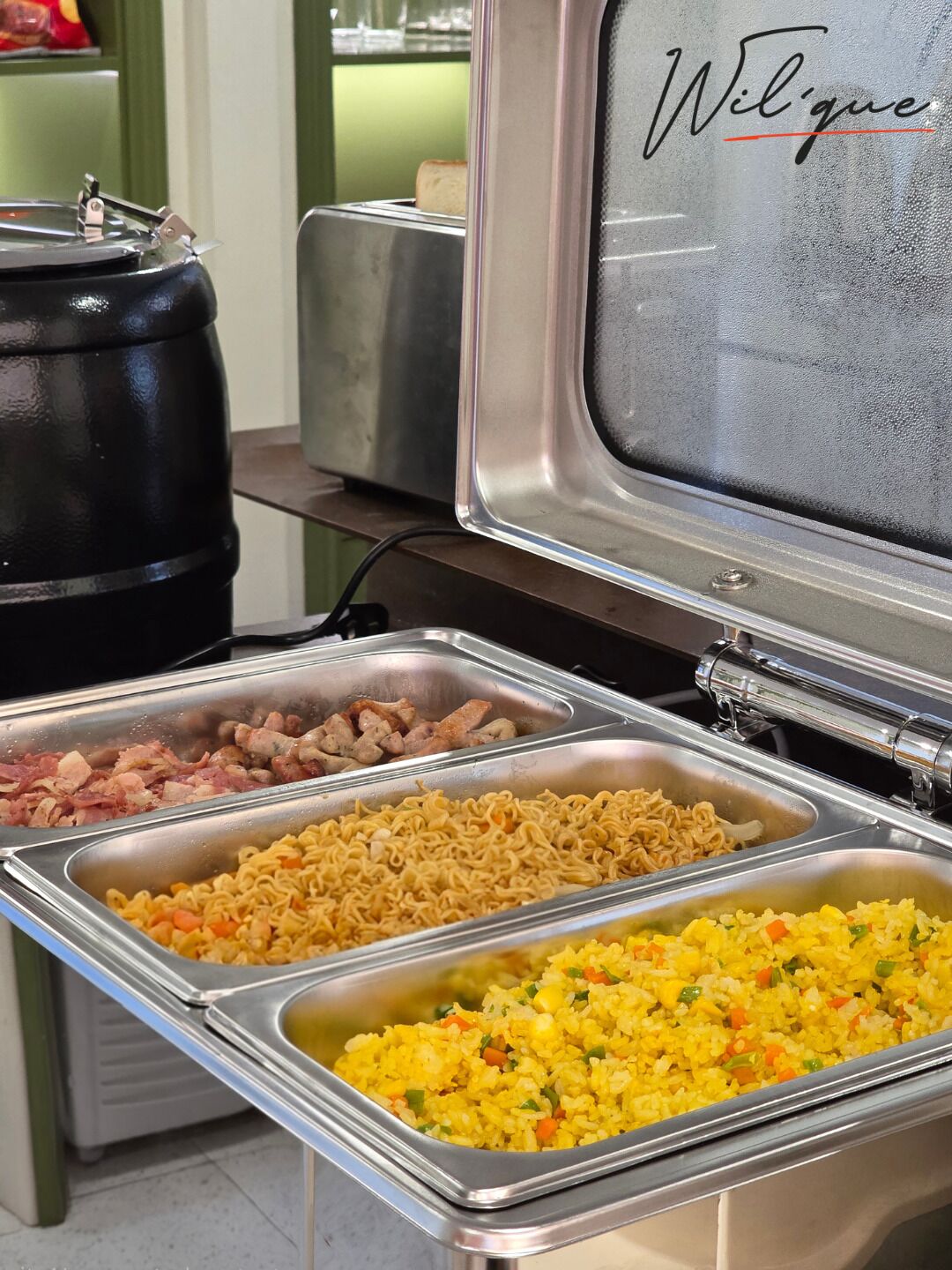 A buffet with various food options including noodles, fried rice, and meats.
