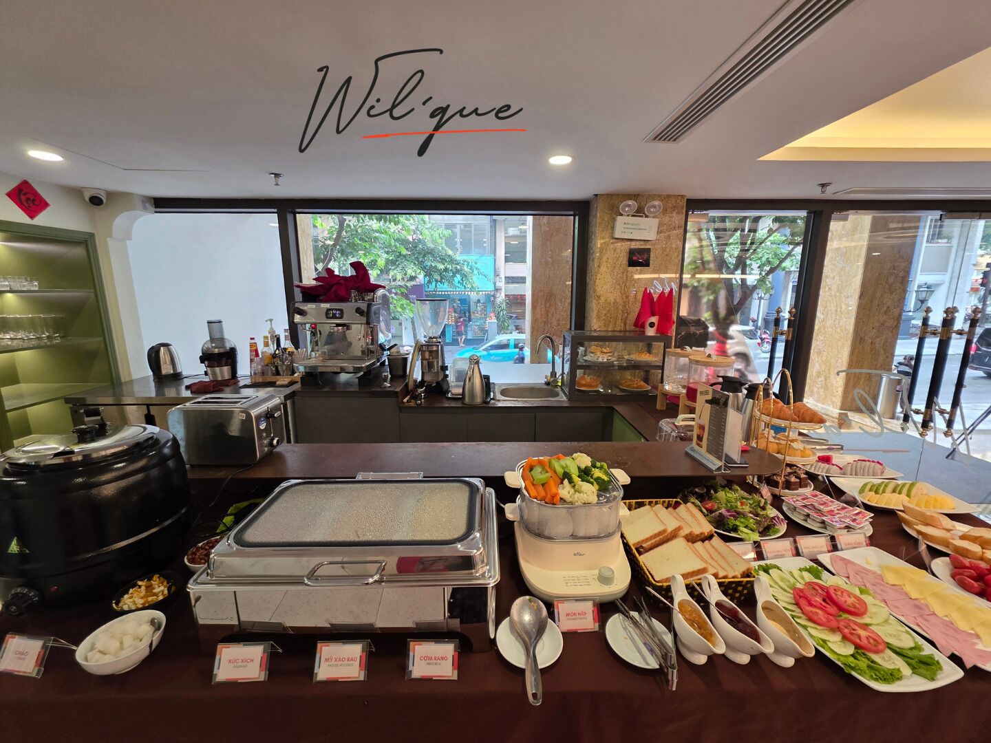 A buffet setup with various food items and a coffee station.