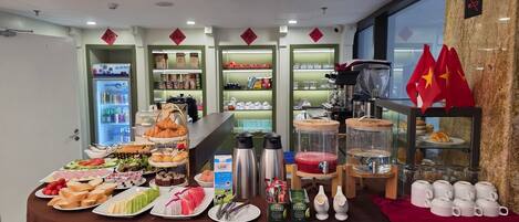 Un área de comida con diversos platos, una estación de café y un letrero que dice 'Welcome'.