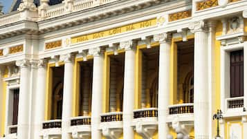 A building with ornate columns and balconies, featuring classical architectural elements.