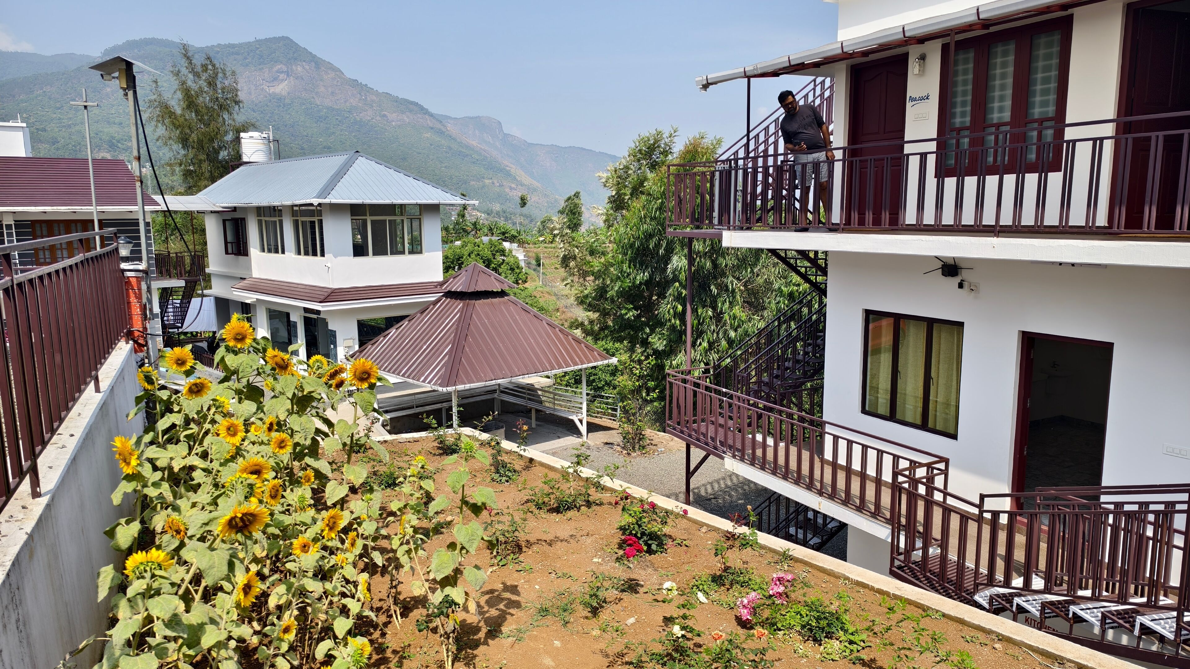 Um edifício residencial com varanda, alpendre e vista para montanhas.