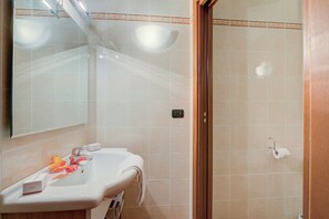 Een badkamer met een wastafel, spiegel en toiletrolhouder.