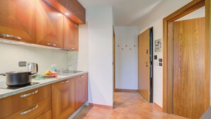 A kitchen with wooden cabinets, a stove, and a sink.