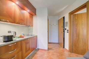 Une cuisine avec des meubles de rangement en bois, une cuisinière et un évier.