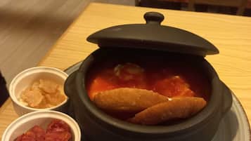 Savor a hearty meal at this casual dining table, complete with a steaming pot and crispy accompaniments.