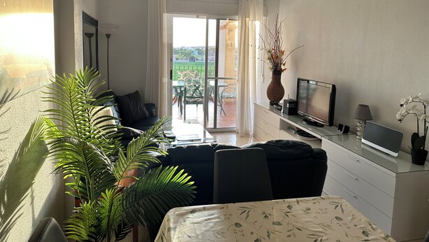 Un soggiorno moderno con un divano, una TV e un'area pranzo con tavolo e sedie.